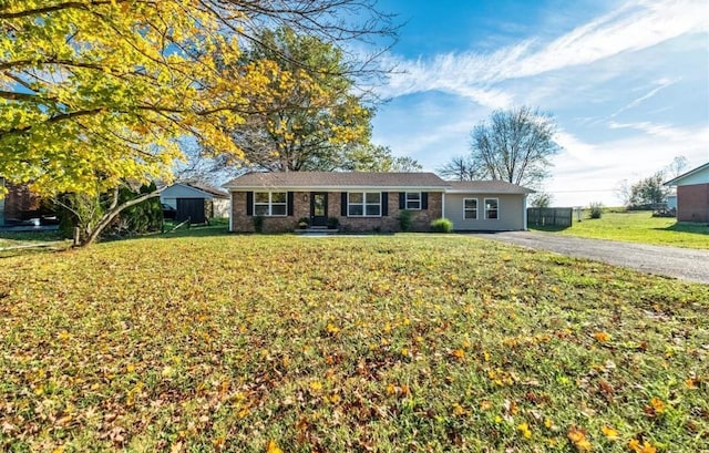 ranch-style house featuring aphalt driveway and a front yard