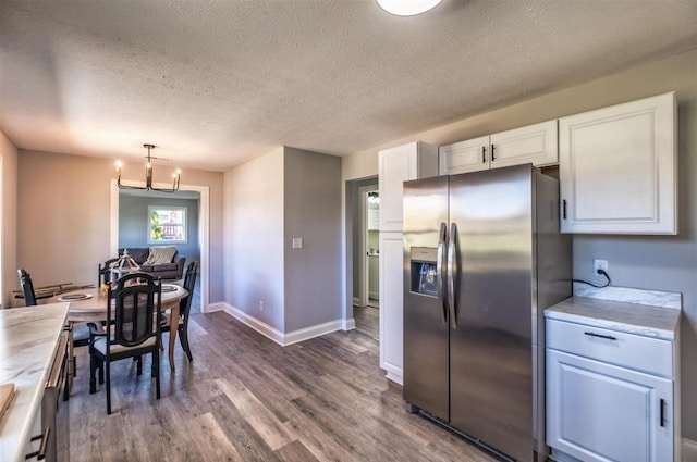 kitchen with a chandelier, wood finished floors, white cabinets, light countertops, and stainless steel fridge with ice dispenser