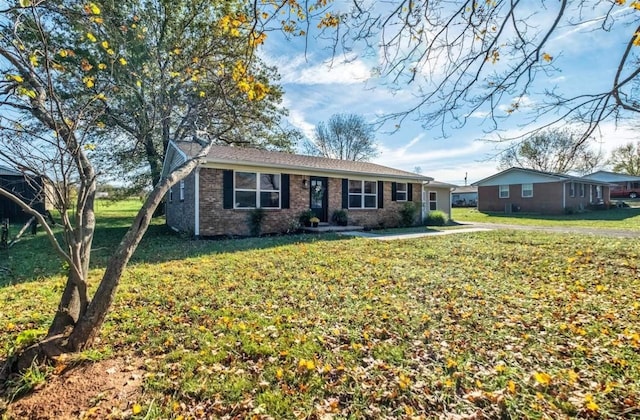 single story home featuring brick siding and a front lawn