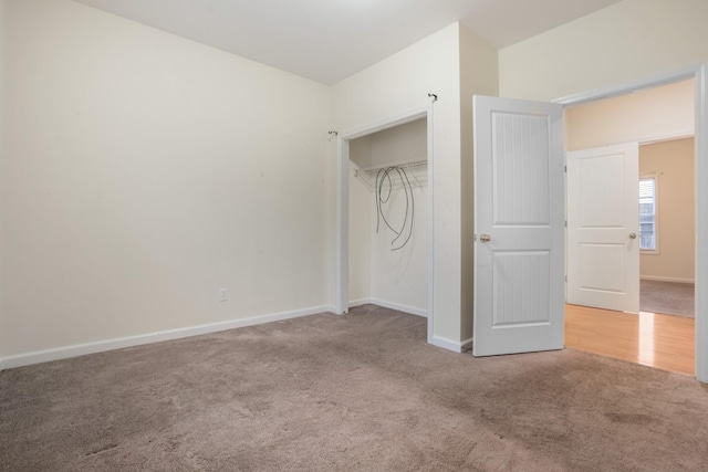 unfurnished bedroom with carpet floors, a closet, and baseboards