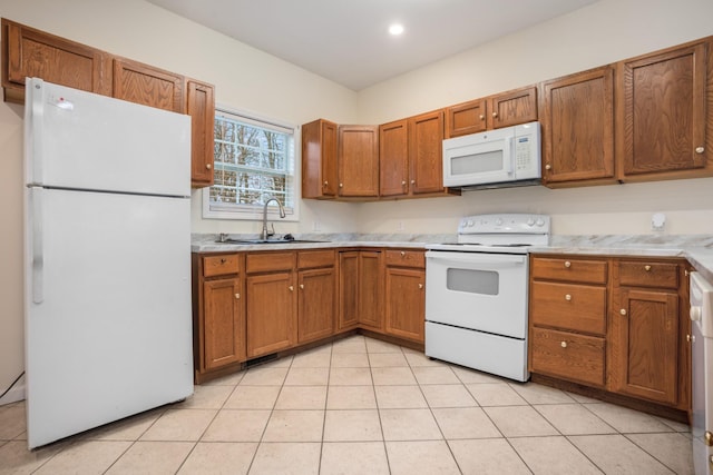 kitchen featuring brown cabinets, white appliances, light countertops, and a sink