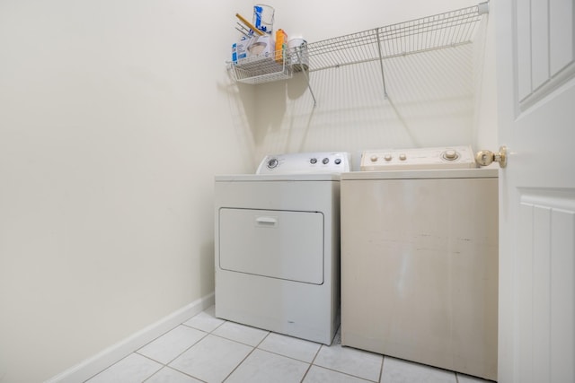 laundry area featuring laundry area, light tile patterned flooring, baseboards, and separate washer and dryer