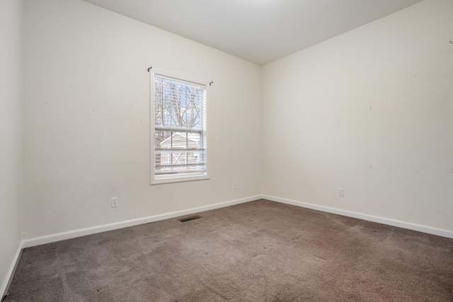 carpeted empty room featuring visible vents and baseboards