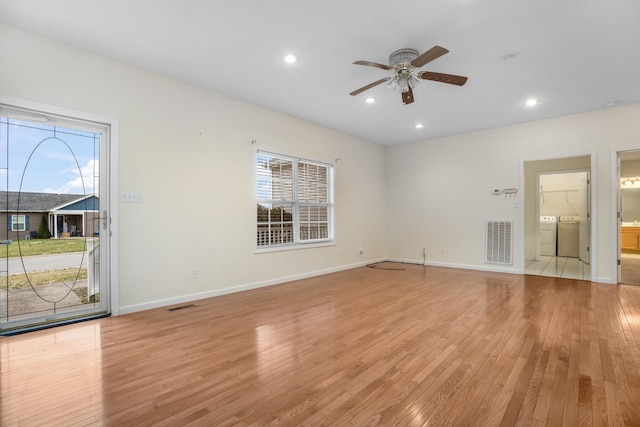 unfurnished living room with light wood-style floors, visible vents, and independent washer and dryer