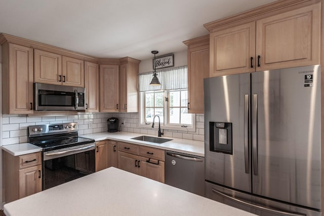 kitchen with stainless steel appliances, light countertops, decorative backsplash, light brown cabinets, and a sink