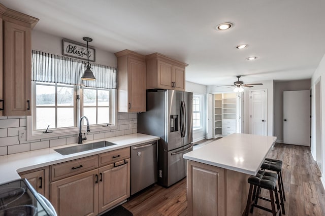 kitchen with a breakfast bar, plenty of natural light, stainless steel appliances, and a sink