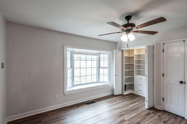 unfurnished bedroom with baseboards, visible vents, ceiling fan, and light wood finished floors