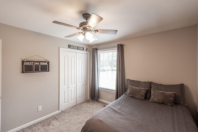 bedroom with light carpet, a ceiling fan, baseboards, and a closet