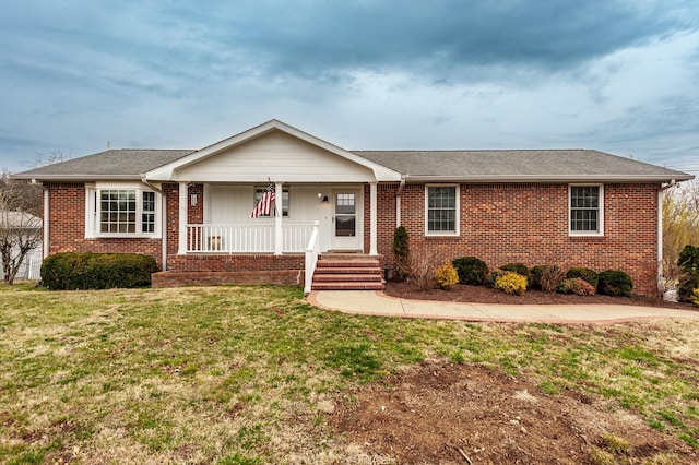 single story home with a shingled roof, covered porch, brick siding, and a front lawn