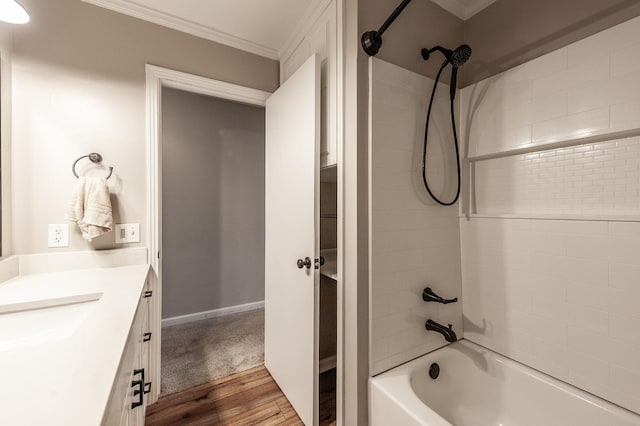 bathroom featuring crown molding, washtub / shower combination, vanity, wood finished floors, and baseboards