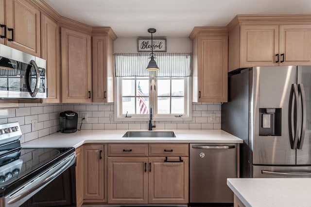 kitchen featuring a sink, light countertops, appliances with stainless steel finishes, backsplash, and light brown cabinetry