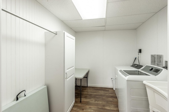 washroom featuring dark wood-style flooring, laundry area, a sink, and washing machine and clothes dryer