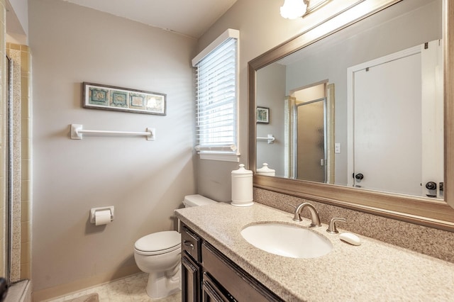 bathroom with toilet, a shower stall, and vanity