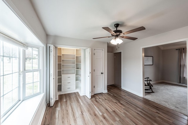 unfurnished bedroom with light wood-style flooring, baseboards, and ceiling fan