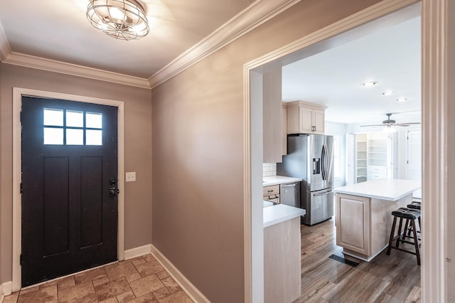 entryway featuring visible vents, ornamental molding, a ceiling fan, stone finish floor, and baseboards