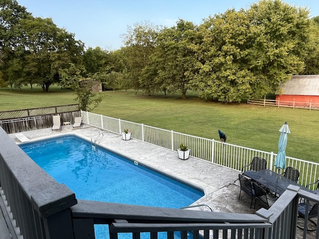 view of pool with a patio area, a fenced backyard, a fenced in pool, and a lawn