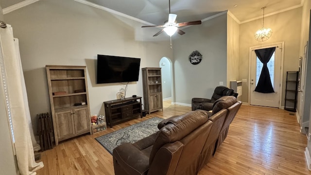 living area with arched walkways, radiator, ceiling fan, ornamental molding, and light wood-style floors