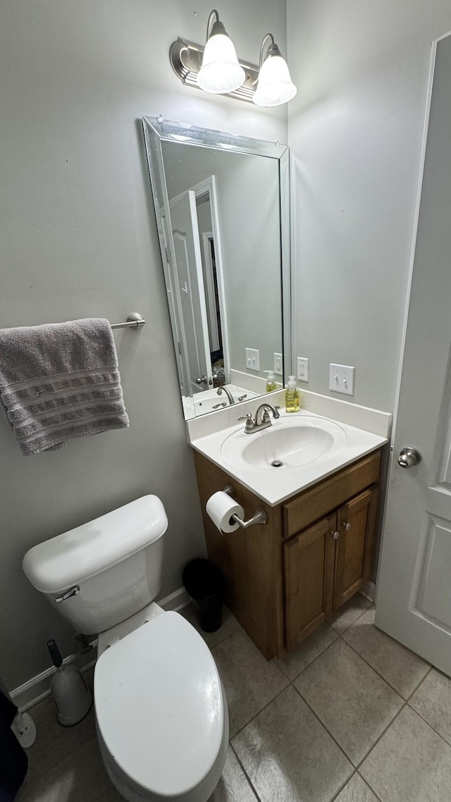 half bathroom featuring vanity, toilet, and tile patterned floors