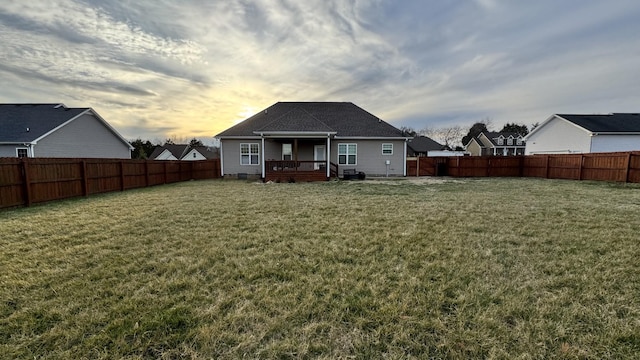 back of property featuring a fenced backyard and a lawn