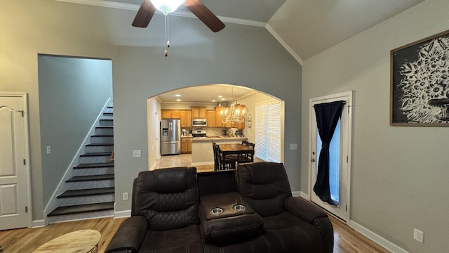 living room with lofted ceiling, light wood finished floors, stairway, and crown molding