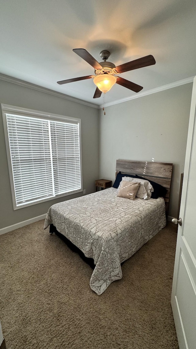 carpeted bedroom with ornamental molding, baseboards, and a ceiling fan