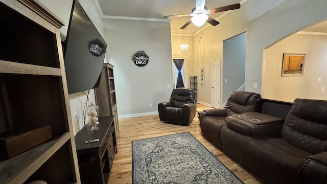 living area with light wood-type flooring, ceiling fan, ornamental molding, and baseboards