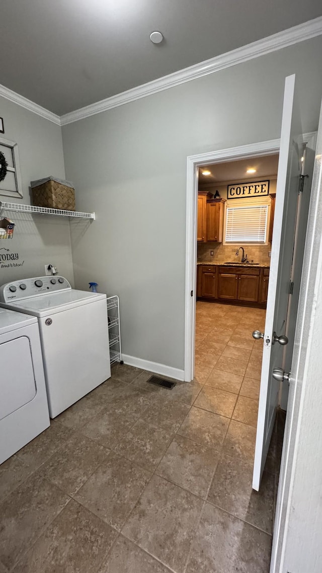 washroom featuring laundry area, a sink, baseboards, independent washer and dryer, and crown molding