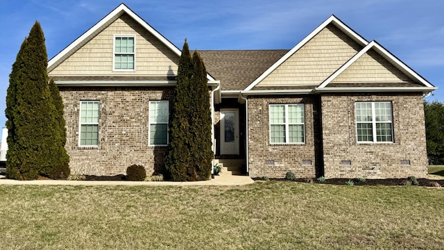 view of front of home with roof with shingles, brick siding, crawl space, and a front lawn