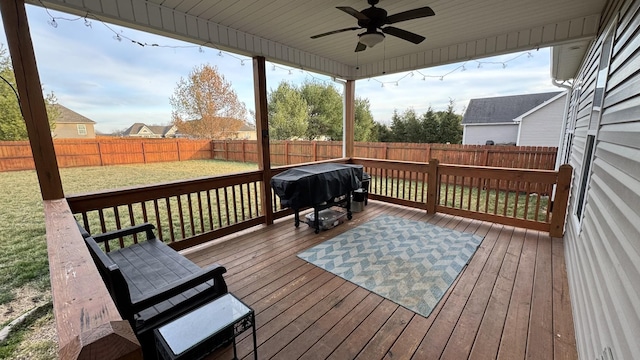 deck with a yard, a grill, a fenced backyard, and ceiling fan