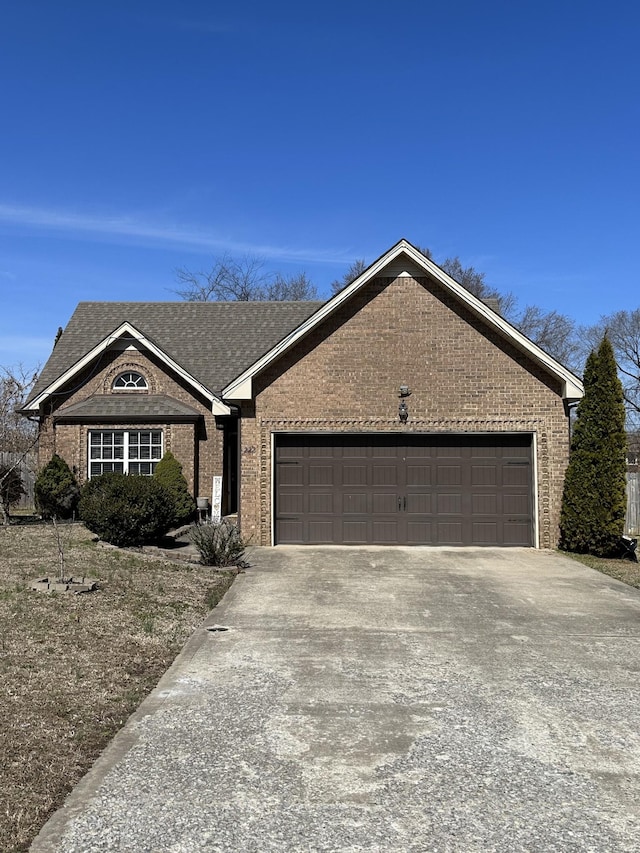 single story home featuring a garage, concrete driveway, and brick siding