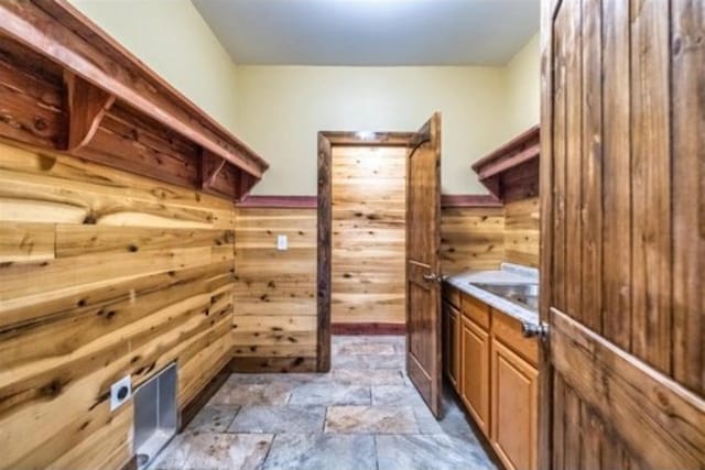 1319 Cemetery Rd, Auburn, KY 42206 - mudroom featuring a wainscoted wall, wooden walls, and stone finish floor