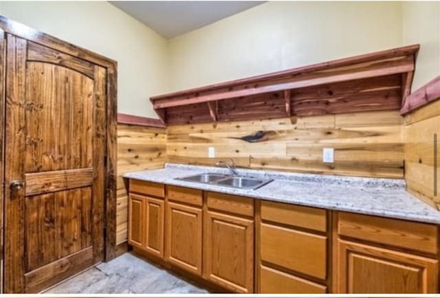 1319 Cemetery Rd, Auburn, KY 42206 - interior space featuring brown cabinetry, a sink, light stone countertops, and wooden walls