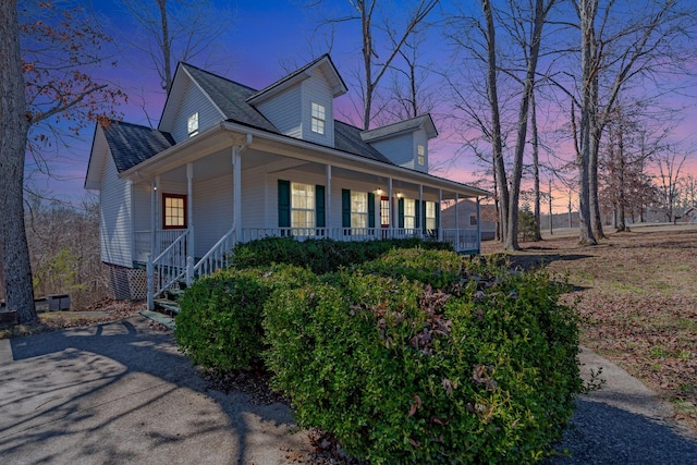 view of home's exterior featuring covered porch and a shingled roof