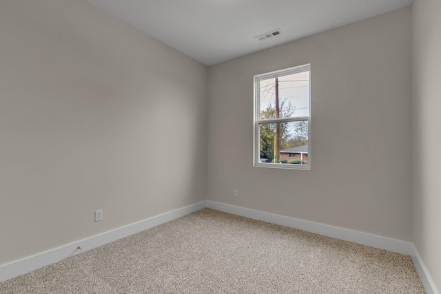 empty room featuring baseboards, visible vents, and light colored carpet