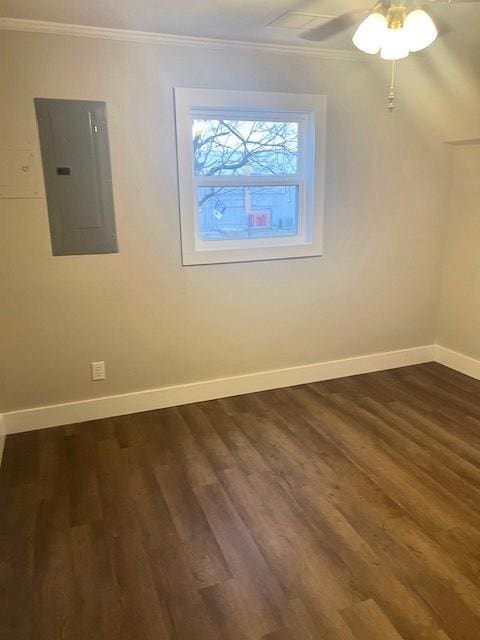 unfurnished room with ornamental molding, baseboards, electric panel, and dark wood-type flooring