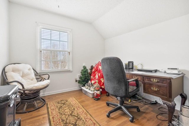 office area featuring lofted ceiling, a textured ceiling, baseboards, and wood finished floors