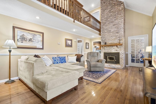 living area featuring wood-type flooring, a high ceiling, baseboards, and crown molding