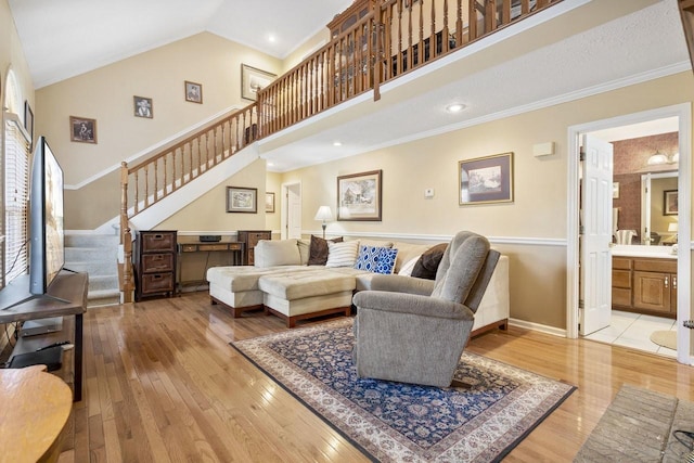 living room featuring crown molding, stairs, high vaulted ceiling, and hardwood / wood-style floors