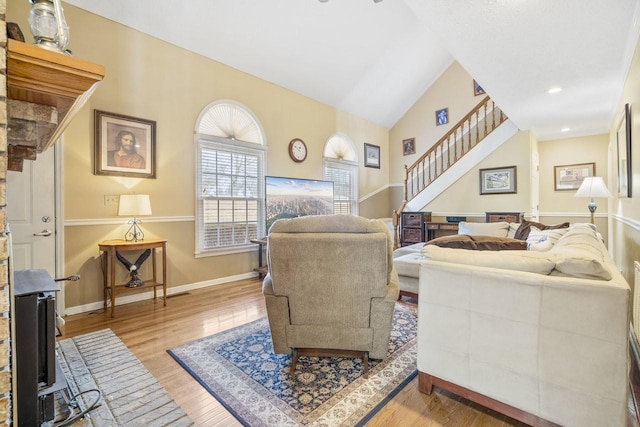 living area with lofted ceiling, recessed lighting, wood finished floors, baseboards, and stairs