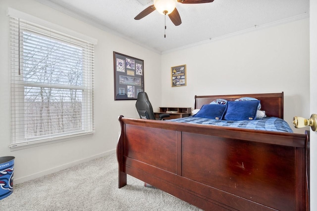 bedroom with baseboards, ceiling fan, a textured ceiling, crown molding, and carpet floors