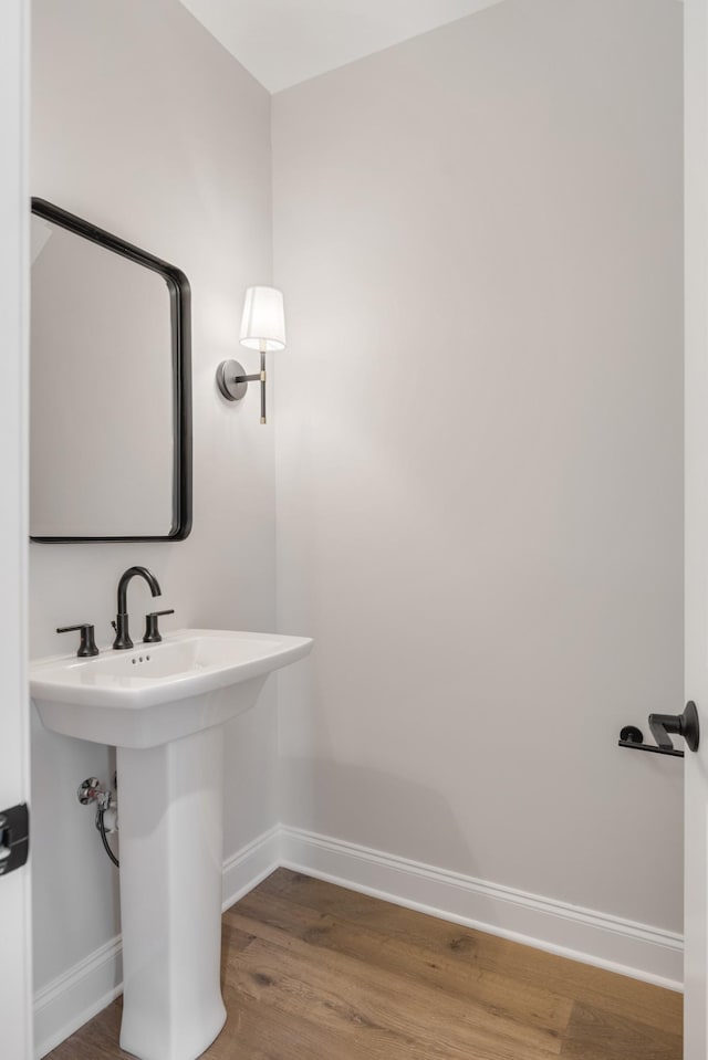 bathroom featuring a sink, wood finished floors, and baseboards