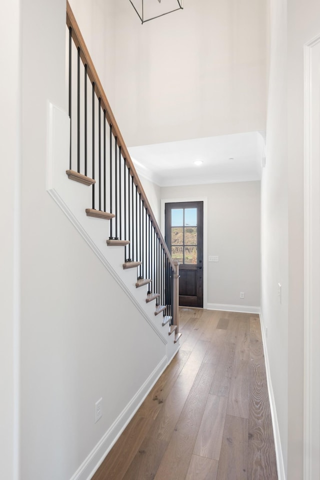 foyer entrance featuring stairs, wood-type flooring, and baseboards