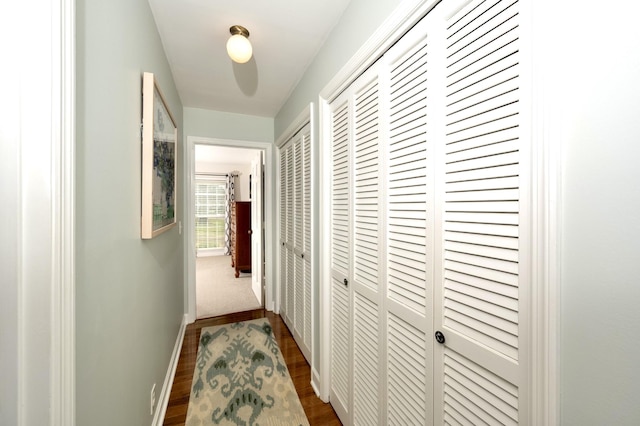 hall with baseboards and dark wood-style flooring