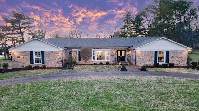 ranch-style house featuring a front lawn and brick siding