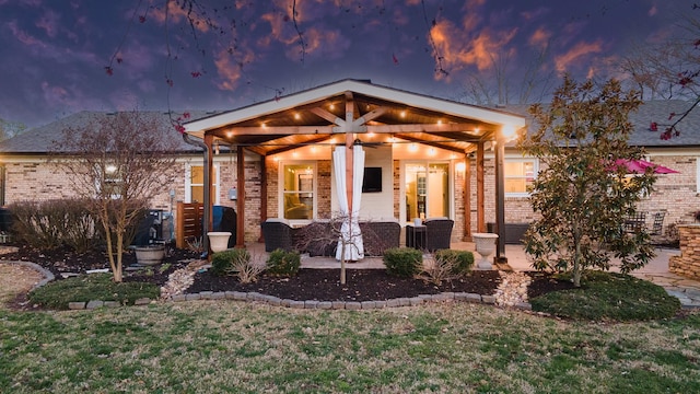 view of front of home featuring a patio and brick siding