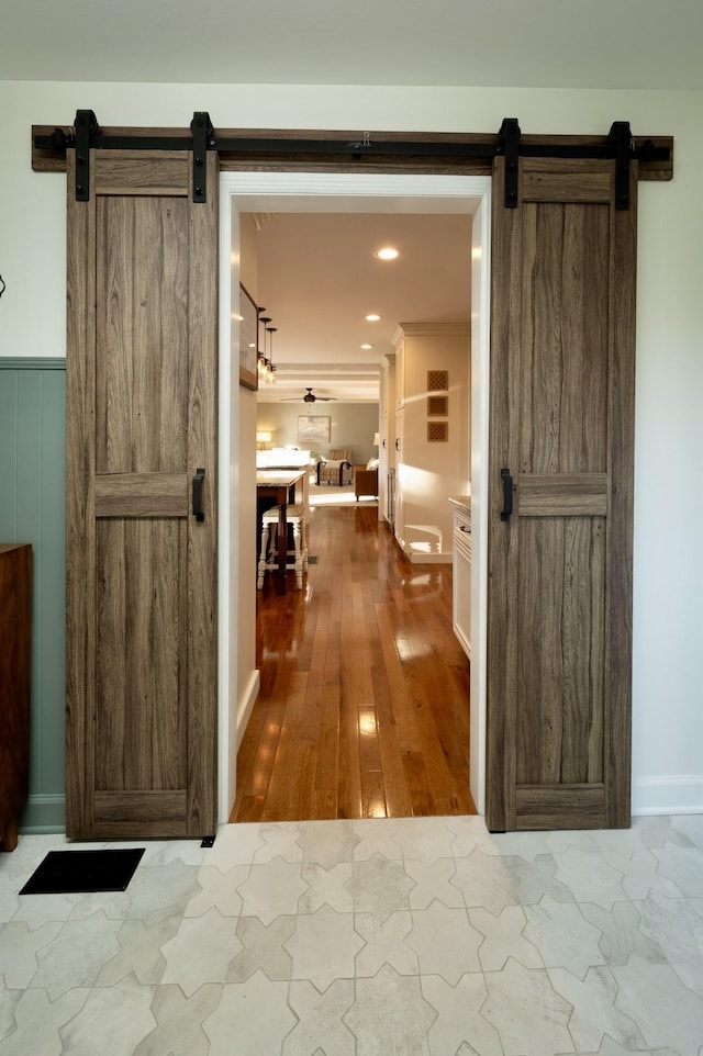 hallway with a barn door and hardwood / wood-style floors