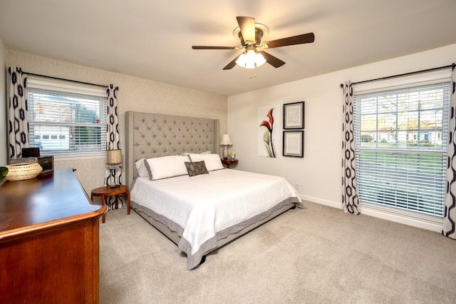 bedroom featuring multiple windows, carpet, a ceiling fan, and baseboards