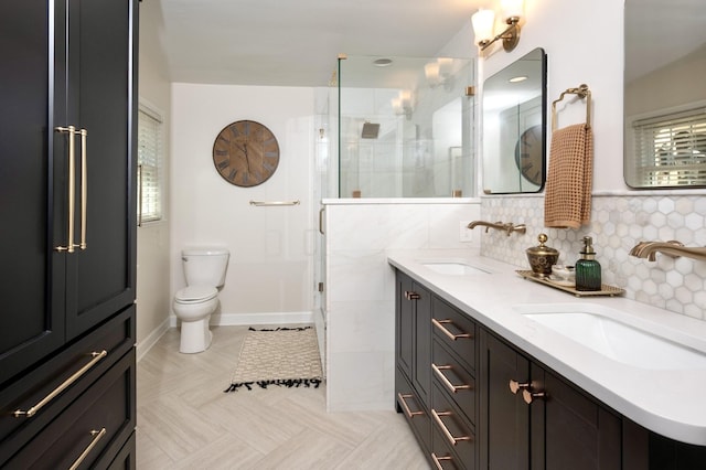 bathroom with double vanity, a sink, toilet, and a shower stall