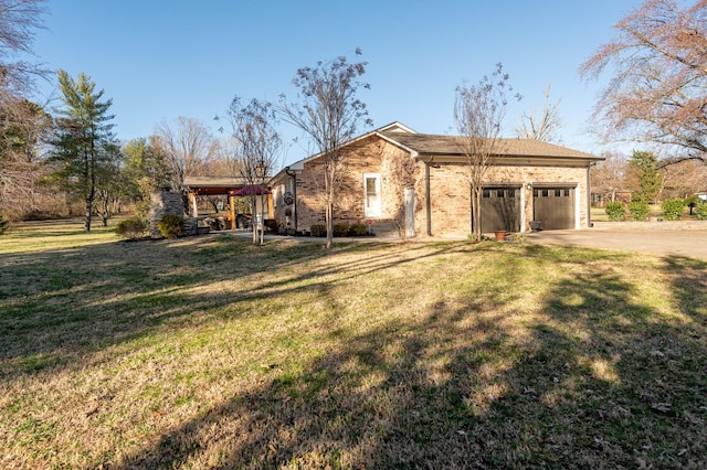 view of front of home with a garage, a front yard, concrete driveway, and brick siding