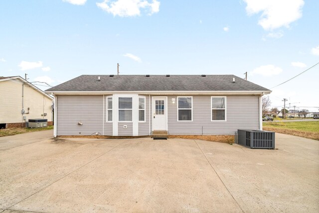 rear view of house featuring central air condition unit, a shingled roof, and a patio